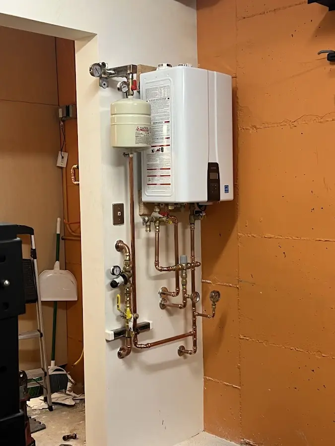 Plumbing technician inspecting water heater connections in Brodhead